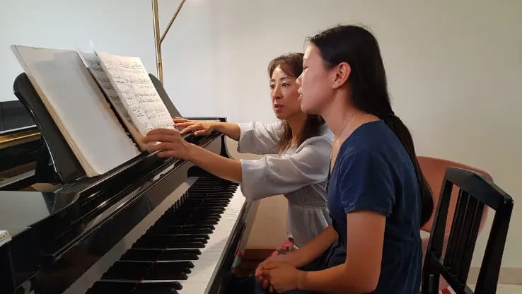 Lien guiding a student through the score during a lesson